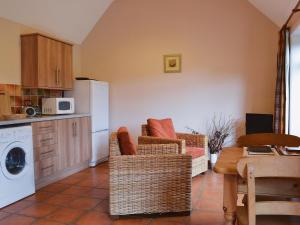a kitchen with two wicker chairs and a white refrigerator at Dill - E4324A in Catfield