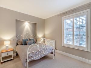 a bedroom with a bed and a window at Pebble Cottage in Weymouth