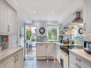 a kitchen with white cabinets and a counter top at Pebble Cottage in Weymouth