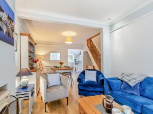 a living room with a blue couch and a table at Pebble Cottage in Weymouth +8 photos