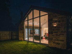 a house with large windows and a yard at night at 13 Shearling - Ukc8974 in Warkworth