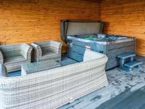 two wicker chairs and a table and a wooden wall at 13 Shearling - Ukc8974 in Warkworth