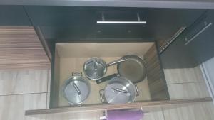 three pots and pans on a shelf in a box at Apartament Masovia in Mrągowo