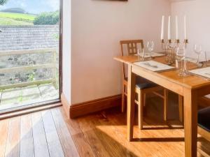 a dining room with a wooden table and a window at Stewards Granary - Uk48306 in Berwick-Upon-Tweed