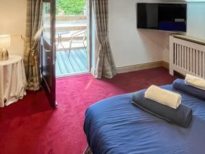 a hotel room with a bed and a balcony at Stewards Granary - Uk48306 in Berwick-Upon-Tweed