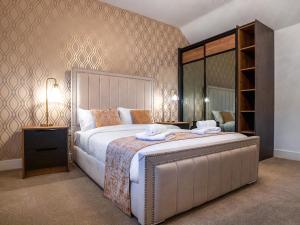 a bedroom with a large bed and a mirror at 12 Galloway - Ukc8975 in Warkworth