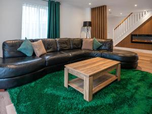 a living room with a leather couch and a coffee table at 12 Galloway - Ukc8975 in Warkworth +11 photos