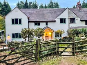 a white house with a wooden fence in front of it at Cannock Chase in Rugeley