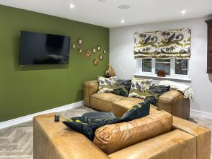 a living room with two leather couches and a flat screen tv at Cannock Chase in Rugeley +18 photos