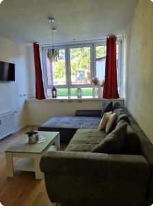 a living room with a couch and a table at Fewo-Am-alten-Bahnhof in Tangerhütte