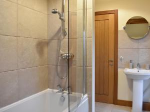 a bathroom with a shower with a tub and a sink at Pippa's Cottage - Uk42332 in Little Blencow