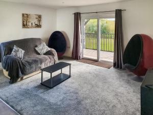 a living room with a couch and chairs and a sliding glass door at Classroom One - Uk48650 in Lifton