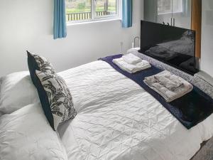a white bed with towels on it in a bedroom at Classroom One - Uk48650 in Lifton