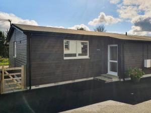 a small house with a fence in front of it at Classroom One - Uk48650 in Lifton +3 photos