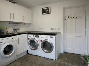 a kitchen with two washing machines and a washer and dryer at Foxes Reach - Hw7421 in Trelleck +9 photos