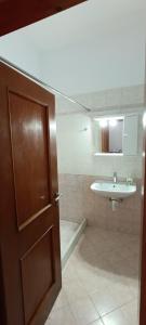 a bathroom with a wooden door and a sink at Siel Oneiro House in Ermoupoli +43 photos