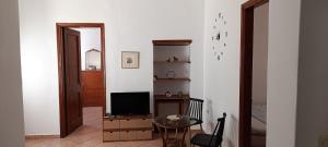 a living room with a table and a television at Siel Oneiro House in Ermoupoli