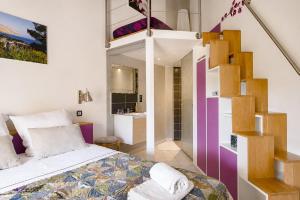 a bedroom with a bed and a spiral staircase at Cap Anguilla, chambre d'hôtes in Carnoux