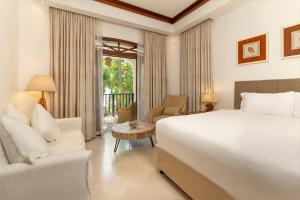 a bedroom with a large bed and a living room at Village du Pecheur in Baie Sainte Anne