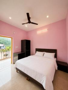 a bedroom with a large bed with a pink wall at Aurelia Ridge in Bīr +4 photos