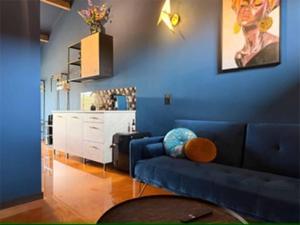 a blue living room with a blue couch and a white cabinet at De Hombrake, Bed & Breakfast in Wilp
