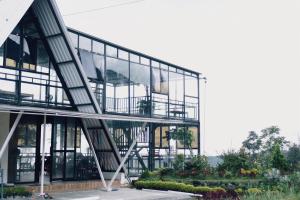 an office building with glass windows and a balcony at CYB Merbabu Resort & Cafe in Kembang