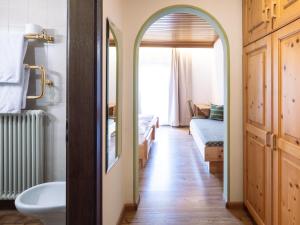 a bathroom with an archway leading to a bedroom at Hotel Hello in Monguelfo +139 photos