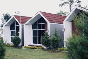 a small white house with a red roof at CYB Merbabu Resort & Cafe in Kembang