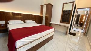 a bedroom with a large bed and a mirror at Sri Durga Residency in Subrahmanya