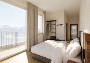 a bedroom with a large bed and a large window at Lasalt - Mountain Legends Hotel in Ischgl
