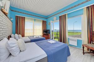 a hotel room with two beds and a balcony at Päeva Villa in Haapsalu