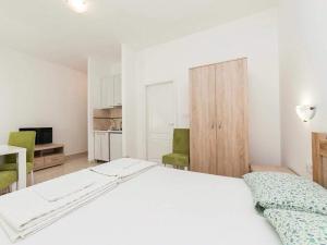 a bedroom with a white bed and green chairs at Studio Apartment in Kaluđerac