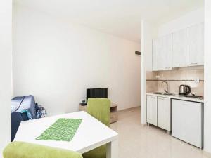 a kitchen with a white table and a green chair at Studio Apartment in Kaluđerac