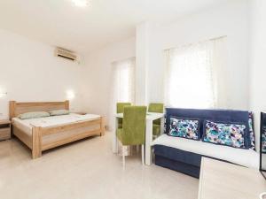 a bedroom with two beds and a desk in it at Studio Apartment in Kaluđerac