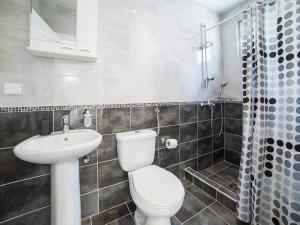 a bathroom with a white toilet and a sink at Studio Apartment in Kaluđerac