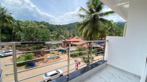 a balcony with a view of a street and a palm tree at Sri Durga Residency in Subrahmanya