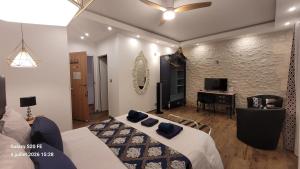 a bedroom with a bed and a desk in a room at Les Cuves - Saintes - Chambres d'hôtes et gîte in Saintes