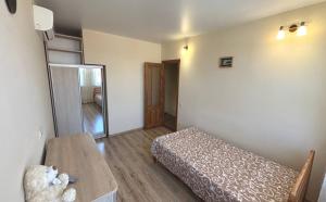 a small room with a bed and a table at Будинок у моря in Odesa
