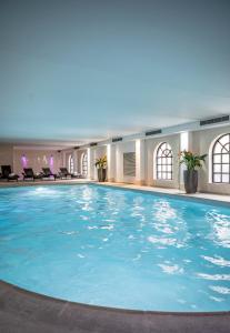 a large swimming pool in a hotel lobby at Brandshatch Place Hotel & Spa in Dartford +31 photos