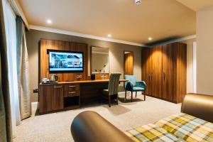 a hotel room with a desk and a television in a room at Dunadry Hotel And Gardens in Antrim