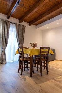 a dining room with a yellow table and chairs at La Stella del Borgo in Castelmezzano