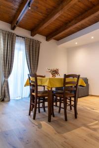 a dining room with a yellow table and chairs at La Stella del Borgo in Castelmezzano +8 photos