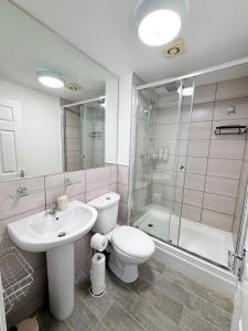a bathroom with a toilet and a sink and a shower at Brit Rooms Manchester in Manchester +50 photos