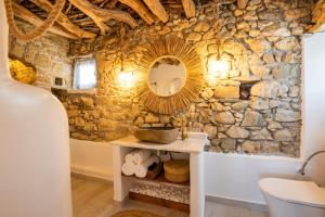 a bathroom with a stone wall and a mirror at Mythos Villa Above the Sunset in Karpathos +82 photos