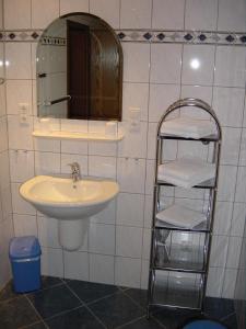 ein Badezimmer mit einem Waschbecken, einem Spiegel und einem Handtuchhalter in der Unterkunft Ferienwohnung Steinebach in Daun