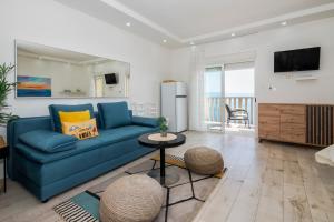 a living room with a blue couch and a tv at SUPER HORIZONT- Sea View Apartments with private Jacuzzi time & Free Parking in Split