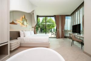 a bedroom with a bed and a desk and a television at The Rachata at Ayothaya in Ban Khlong Takhian +69 photos