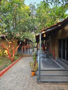 a walkway next to a building with trees at Shunyata Eco Resort Junagadh in Vadal