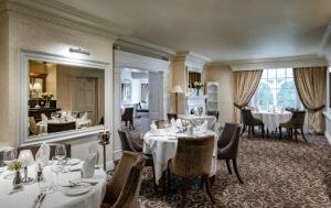 a restaurant with tables and chairs and a mirror at Brandshatch Place Hotel & Spa in Dartford