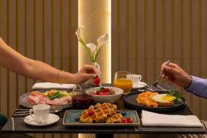 two people sitting at a table with breakfast food at Palazzo Navona Hotel in Rome